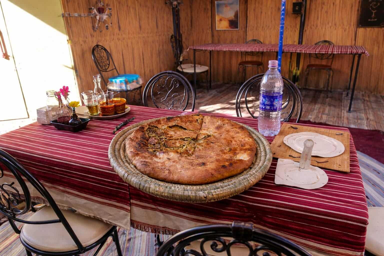 Traditional Berber pizza (Madfouna) during nomad visit in 2 nights camel trekking Merzouga desert